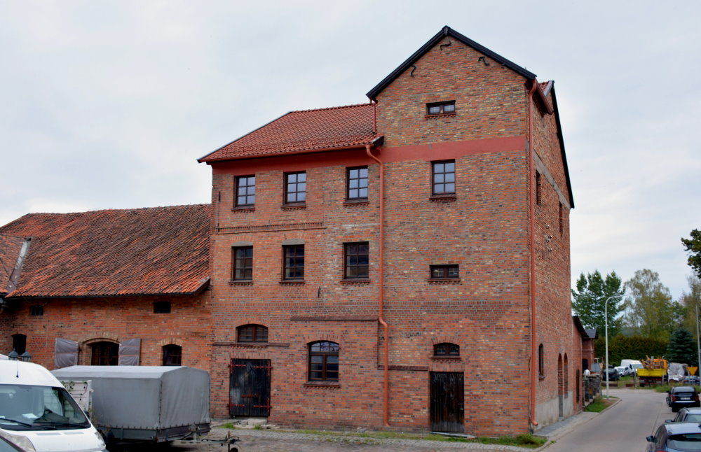 Duży budynek z czerwoenej cegły pokryty dachówką