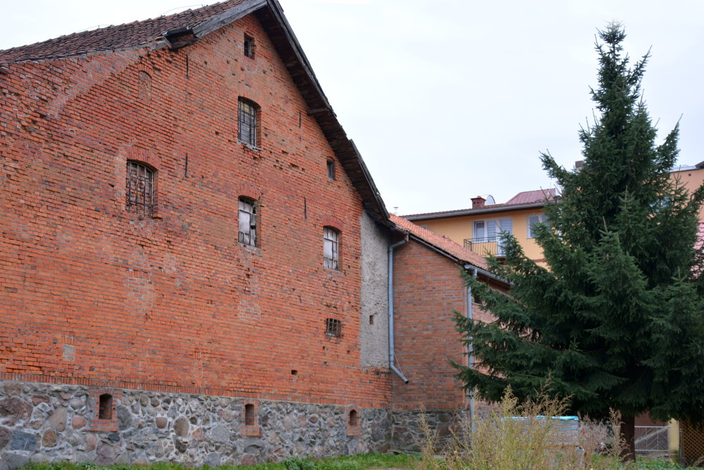 Duży budynek z czerwoenej cegły pokryty dachówką