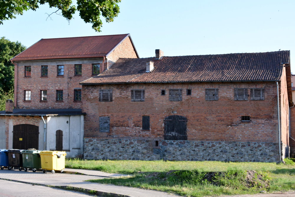 Duży budynek z czerwoenej cegły pokryty dachówką