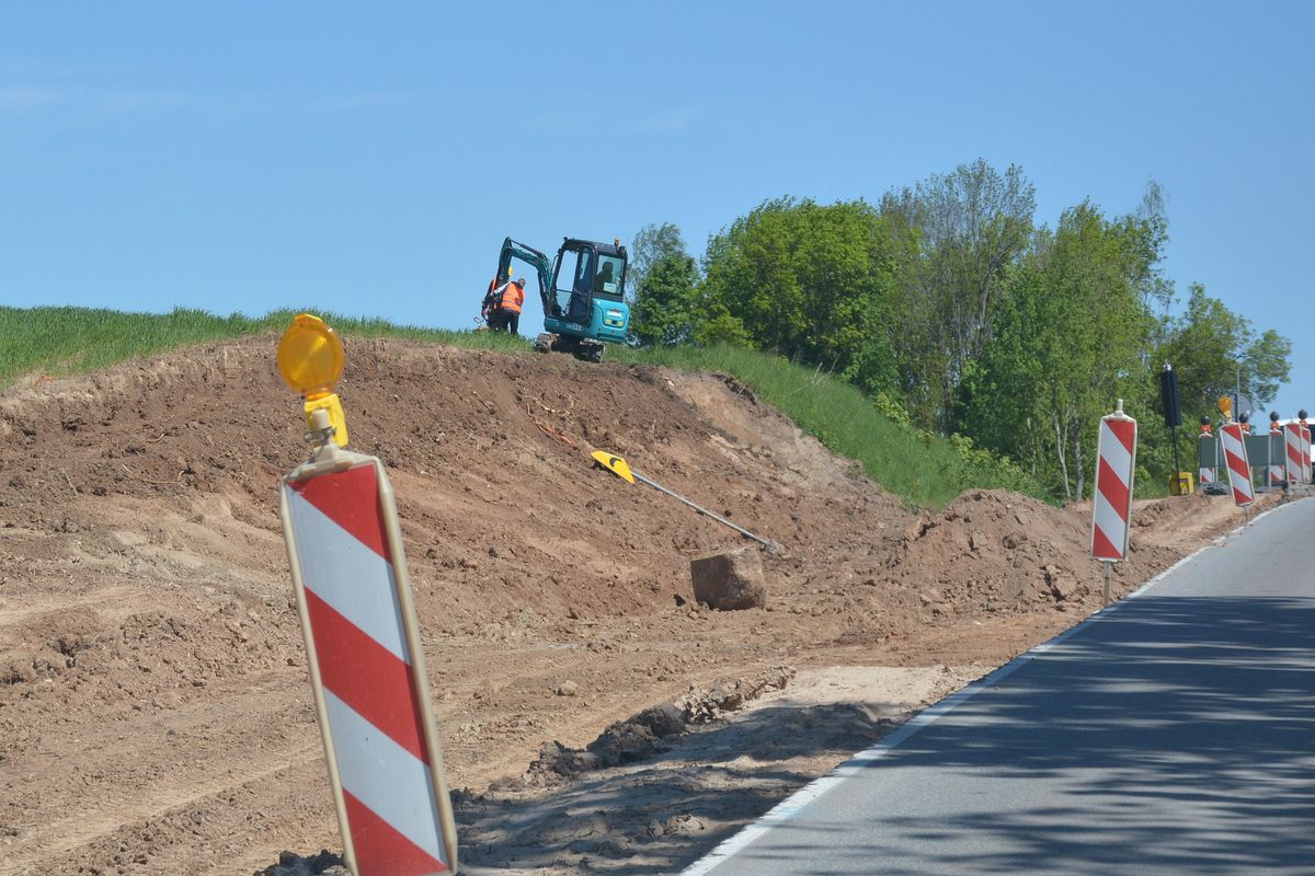 Remont drogi. Widoczna jest koparka na wysokiej skarpie.