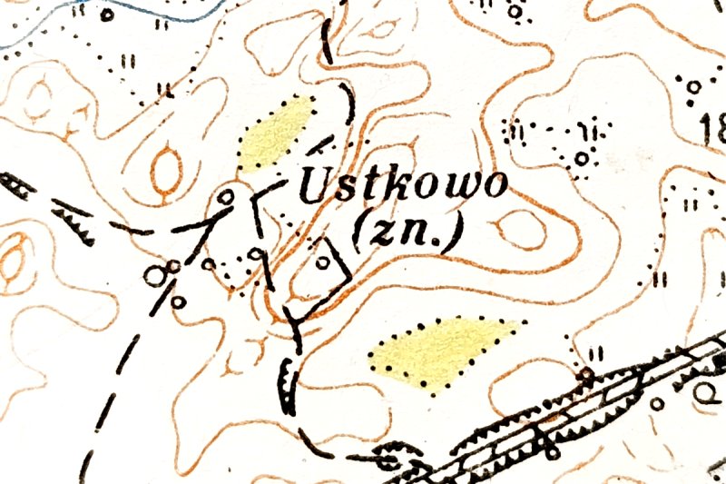 Fragment mapy topograficznej z zaznaczoną miejscowością Ustkowo (zn.), liniami wysokościowymi, drogami, linią kolejową i obszarami zadrzewionymi.