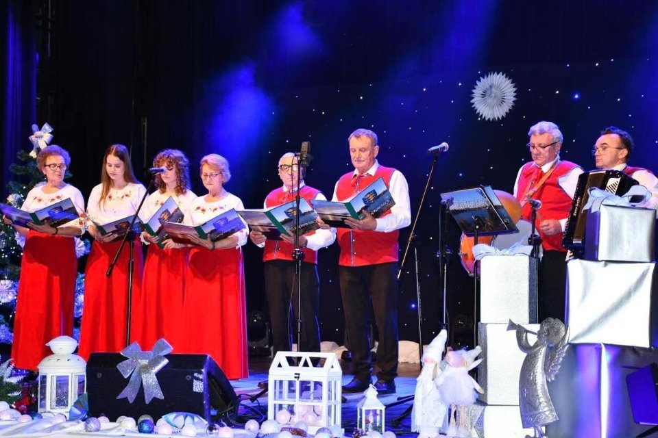 Ch&oacute;r występujący na scenie, śpiewający kolędy podczas koncertu świątecznego.