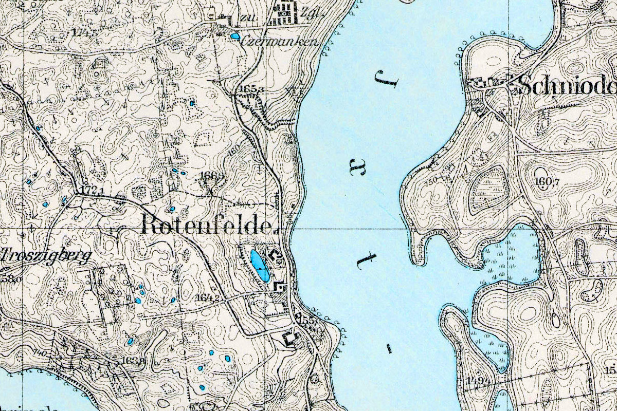 Fragment historycznej mapy z 1927 roku przedstawiającej okolice Rotenfelde z zaznaczonymi akwenami wodnymi, drogami i zabudową.