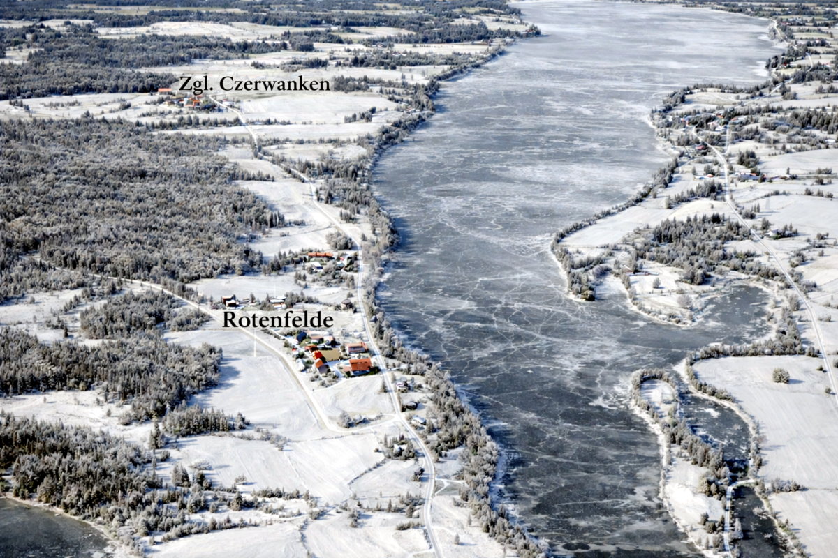 Zimowy krajobraz rzeki w okolicach Rotenfelde &ndash; zamarznięta woda, ośnieżone brzegi i zabudowania widoczne w tle.