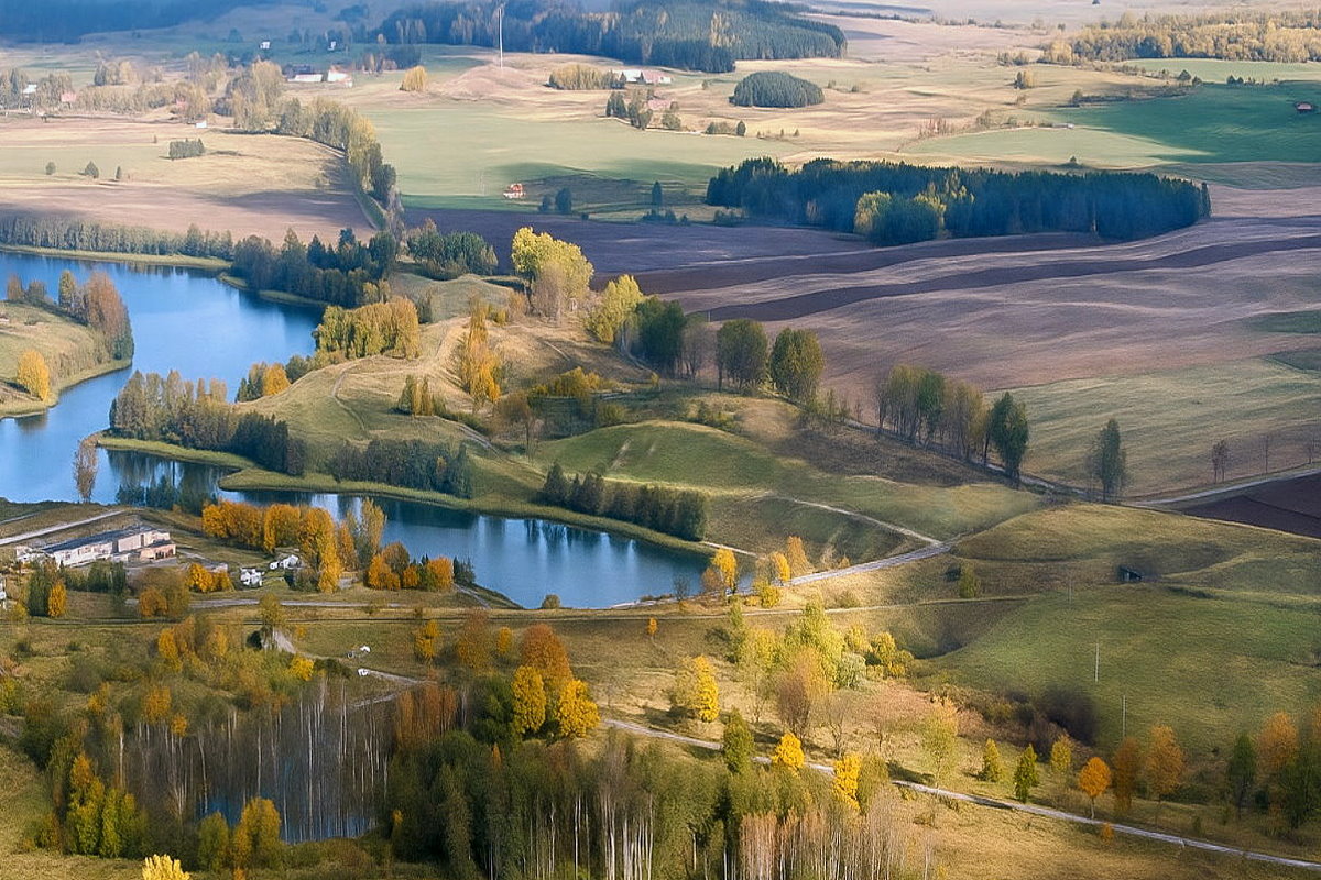 Widok z lotu ptaka na jeziora, pola i pag&oacute;rkowaty krajobraz z mozaiką łąk i zadrzewień.